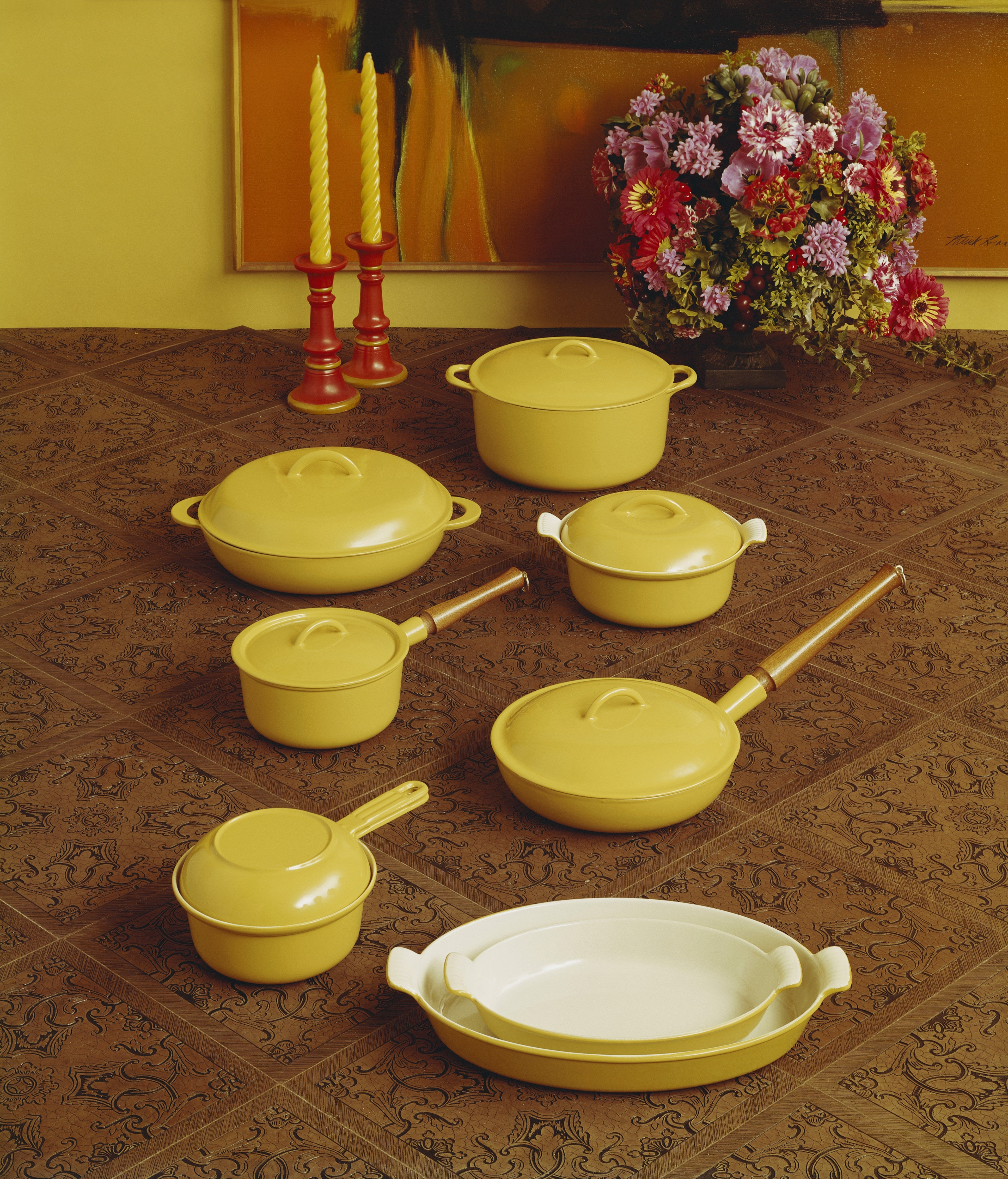 A retro yellow cookware set is displayed on a wood table